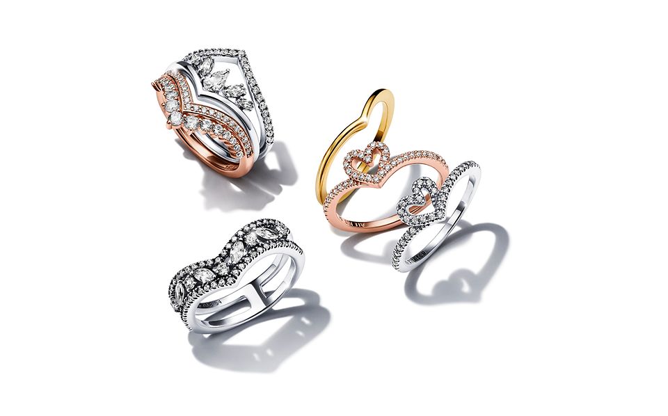 A stack of Pandora Wish rings in various metal finishes.