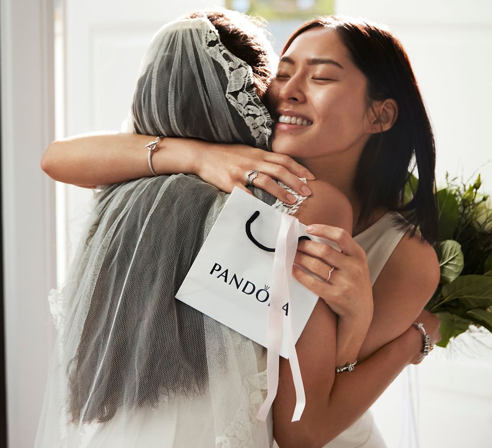 A bride receiving Pandora bridal jewellery as a gift from a friend.