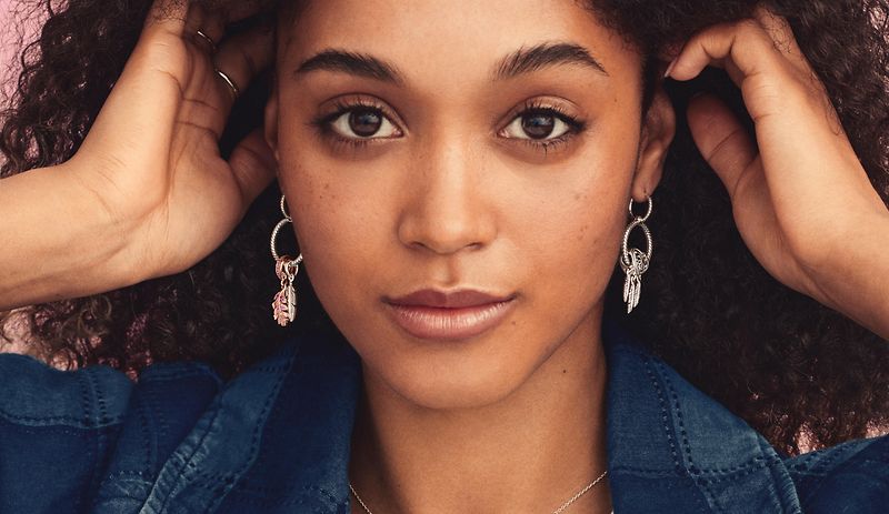 Model wearing Pandora Moments charms on hoop earrings