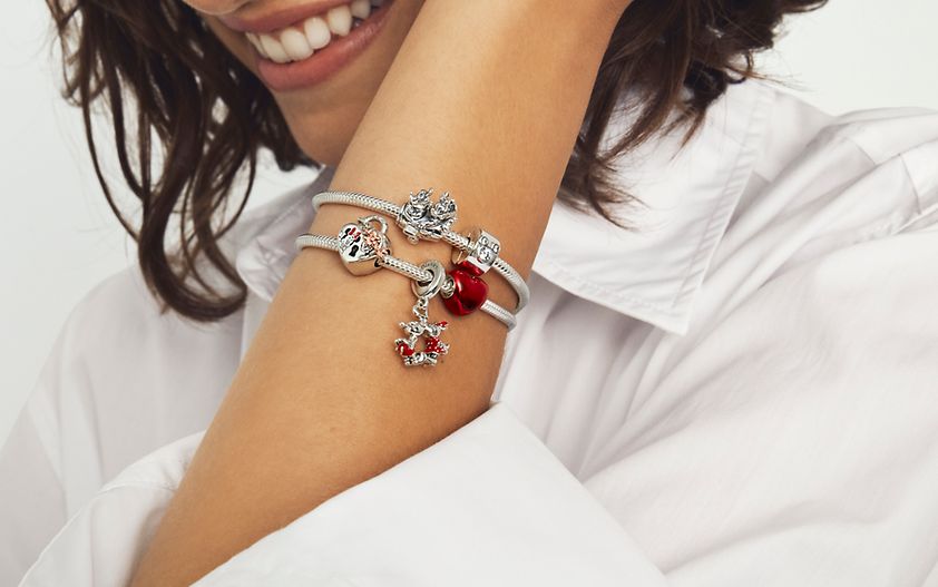 Femme portant un bracelet en argent 925/1000e avec des charms