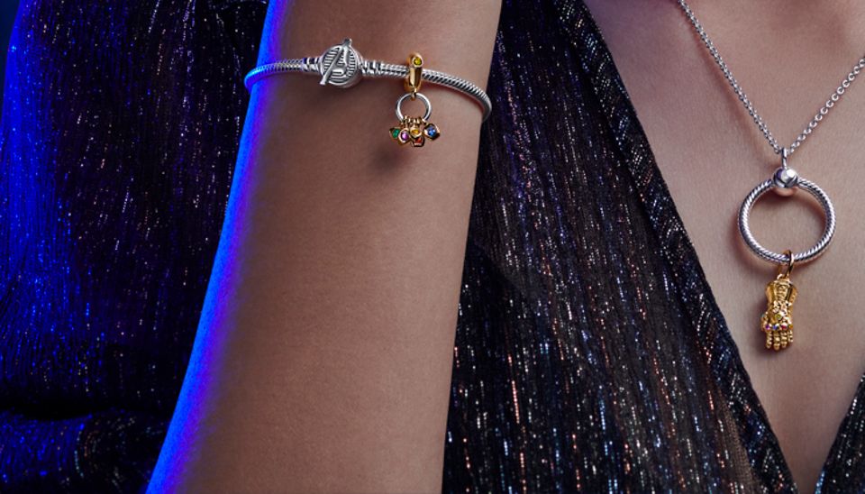 Eine Frau trägt das von den Avengers inspirierte Silberarmband und eine Halskette mit den Avengers Infinity Gauntlet Charm-Anhängern