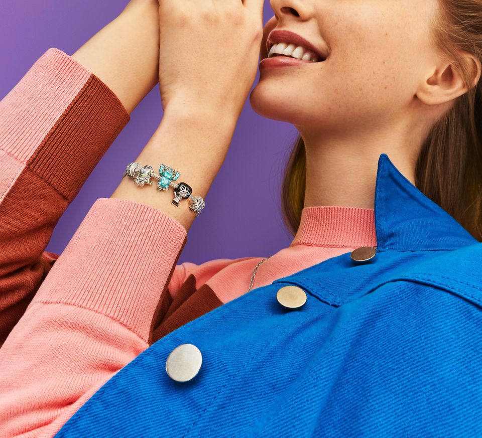 Femme portant un bracelet en argent avec des charms de la collection Pixar