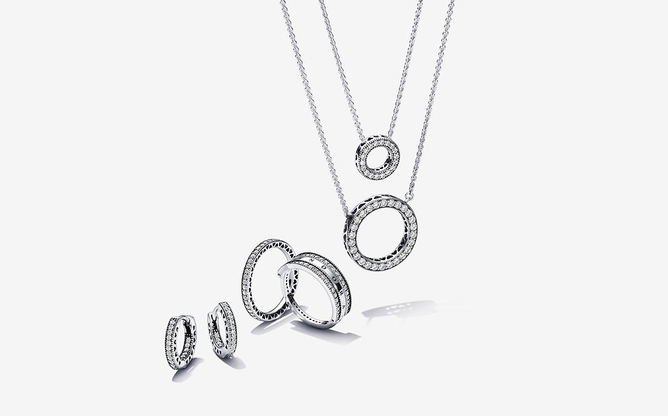 Bild von silbernen Halsketten, Ringen und Ohrringen aus der Signature-Serie von Pandora.