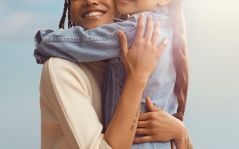 Image of a mother and daughter smiling and embracing.