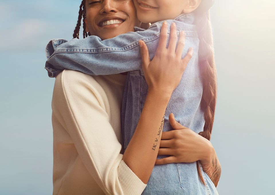 Image d’une mère et de sa fille en train de sourire et de s'enlacer.