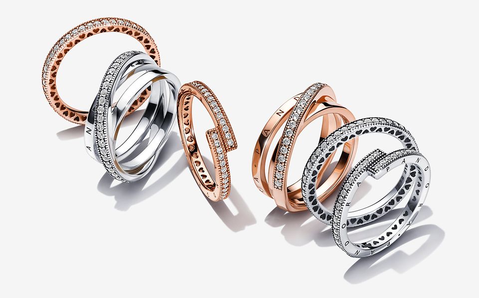 Image of 6 silver and rose gold rings from Pandora Signature collection.