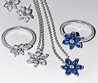 Pary srebrnych i niebieskich pierścionków, kolczyków i naszyjników z kwiatkami z kolekcji Pandora BE LOVE