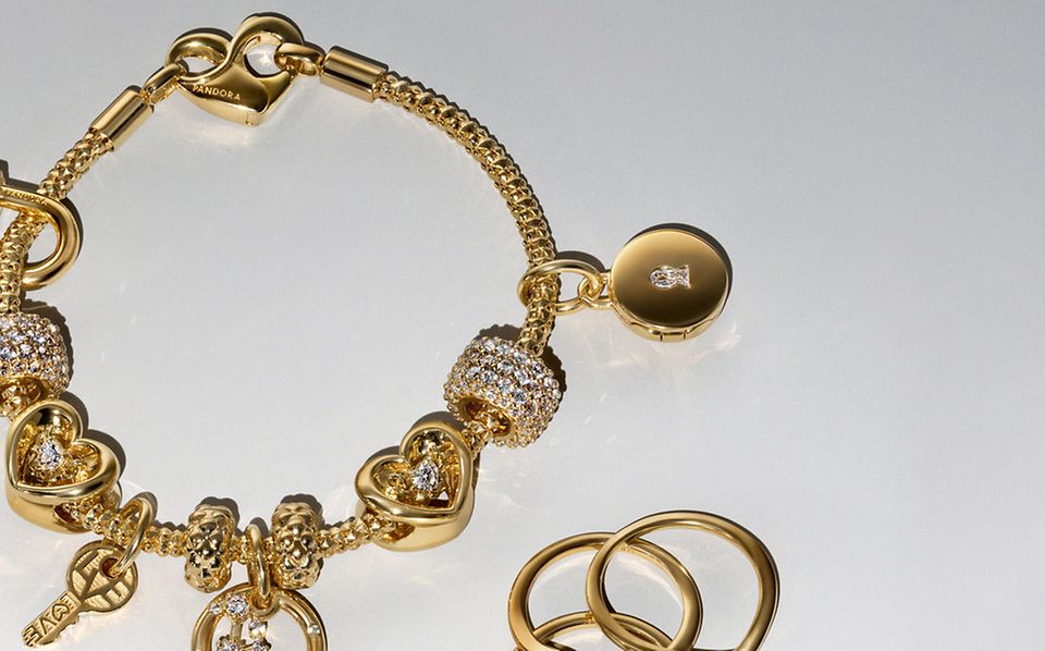 Bild von einem goldenen und mit im Labor gezüchteten Diamanten versehenen Pandora BE LOVE Charm-Armband und fünf Ohrringen