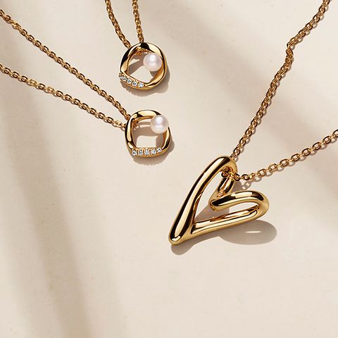 Colección de collares con un recubrimiento en oro de 14k y perlas de PANDORA ESSENCE.